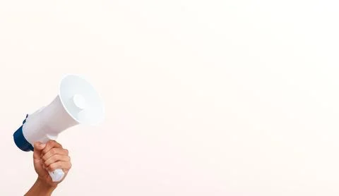 Hand holding white megaphone against white background with copy space for m.. Stock Photos