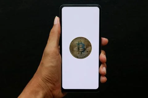 Hand holding a white screen smartphone containing bitcoin Stock Photos