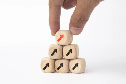 Hand holding wooden cube blocks print up arrow on white background with spa.. Stock Photos