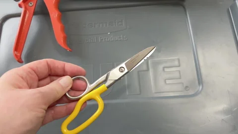 Hand Holding Yellow Handled Scissors Over Toolbox Stock Footage 318236833