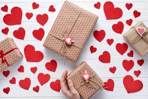 Hand holds and sends a gift for Valentines, birthday. Romantic creative white Stock Photos