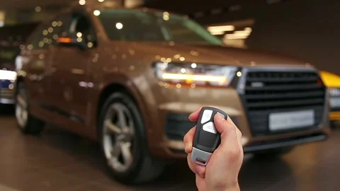 Hand holds and using remote key to unlock a car. Turn signals blinking. Brand Stock Footage 141284979