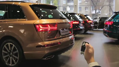 Hand holds and using remote key to unlock 4 cars. Turn signals blinking. Brand Stock Footage 141285006