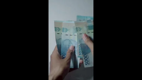 Hand holds banknote against plain background Stock Footage 341084823