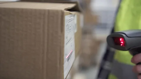 Hand holds a barcode scanner in the warehouse Vídeos de archivo 100766544