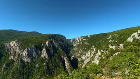 Hand holds binoculars, peering into vast green canyon. Lazar's Canyon, Serbia Stock Footage 345329849