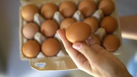 A hand holds a box of eggs. Fresh eggs in a box. Stock Footage 267104089