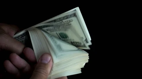 Hand holds a bundle of hundred-dollar bills Stock Footage 130007912