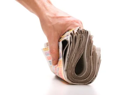 Hand holds a bundle of newspapers 스톡 사진