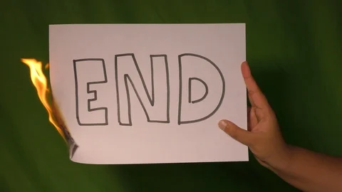 A hand holds the burning paper with end text word on it. Stock Footage 127920848