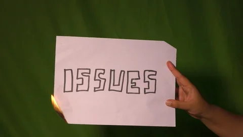 A hand holds the burning paper with issues text word on it. Stock Footage 127921736