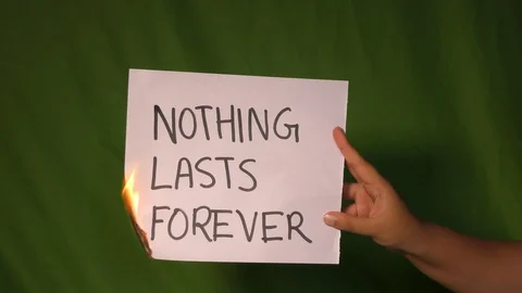 A hand holds the burning paper with nothing lasts forever text word on it. Stock Footage 127921763