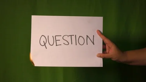 A hand holds the burning paper with question text word on it. Stock Footage 127922342