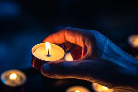 A hand holds a candle Stock Photos