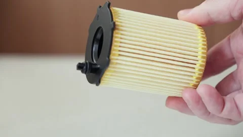 A hand holds a car filter insert designed for oil or fuel purification and .. Stock Footage 319062410