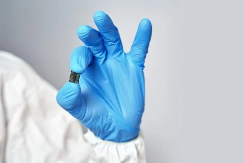 Hand holds chip compenent.. Microchip close-up. Implantation to humanity. Stock Photos