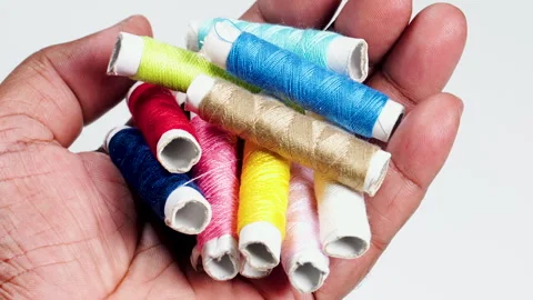 A hand Holds Colored Thread Spools Stock Footage 248701466