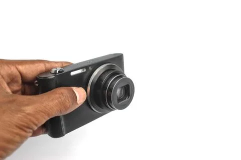 A hand holds a compact camera to take a photo. 库存照片