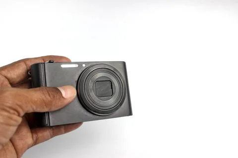 A hand holds a compact camera to take a photo. 库存照片
