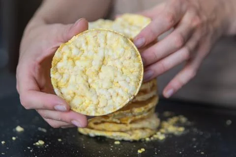 A hand holds corn chips close-up. The process of eating a quick snack in the Stock Photos