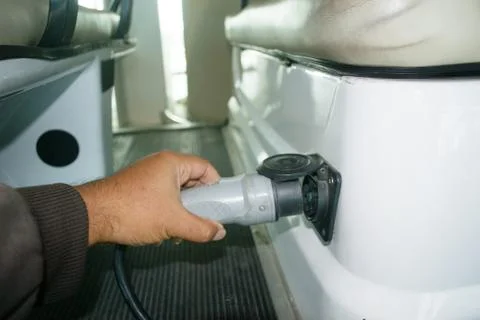 Hand Holds Electric Plug to Start Charging Electric Car Stock Photos