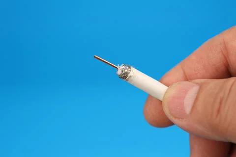 The hand holds the electrical copper wire in insulation. Stockfoto's