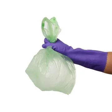 Hand holds an empty green plastic bag on a white background, concept of re... Photos