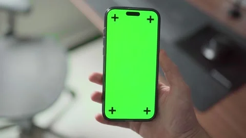 A hand holds an iPhone 16 Pro Max with a green screen and tracking markers Video stock 295131671