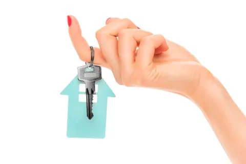 Hand holds key with a keychain the shape of house. Stock Photos