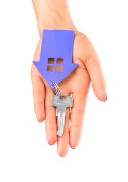Hand holds key with a keychain the shape of house. Stock Photos