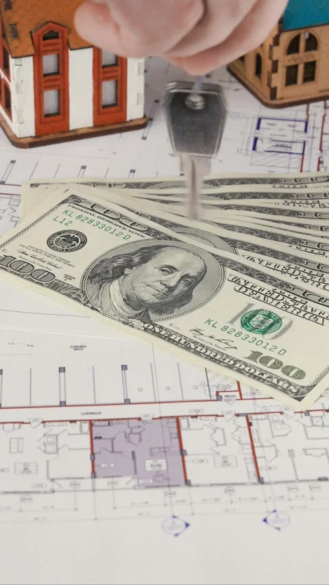 A hand holds a key over real estate blueprints Stock Footage 282676401
