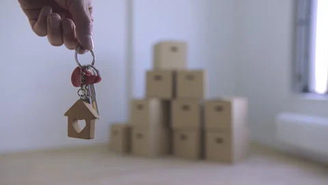 A hand holds keys against a background of boxes. Stock Footage 313679693