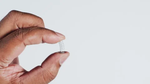 Hand holds a Micro Spring Stock Footage 248754990