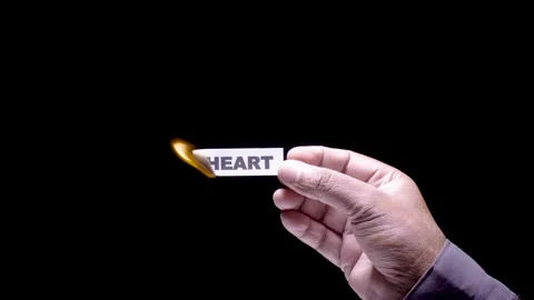 Hand Holds Paper Burning the word Heart Stock Footage 248535802