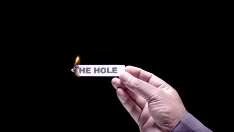 Hand Holds Paper Burning the words In the hole Stock Footage 248535960