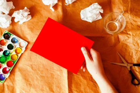 The hand holds the pattern blank. paper. creation. paints and crumpled paper Fotos Stock