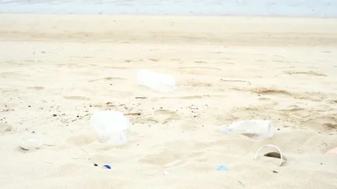 Hand holds plastic bottle on the background of dirty beach. Stock Footage 200637885