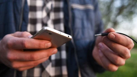 Hand holds the plug and inserts it into the phone jack Stock Footage 130129947