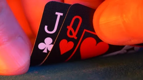 Hand holds queen of hearts and jack of clubs in a game of texas hold em poker 스톡 동영상 263834853