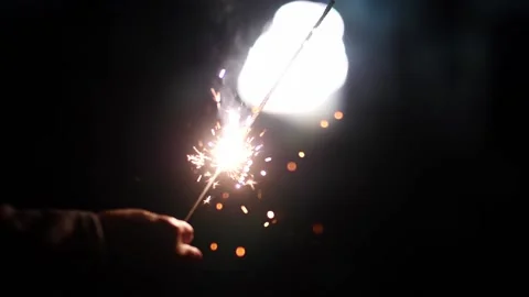 Hand holds the running fire in the warm colors of the festive fireworks Stock Footage 165548098
