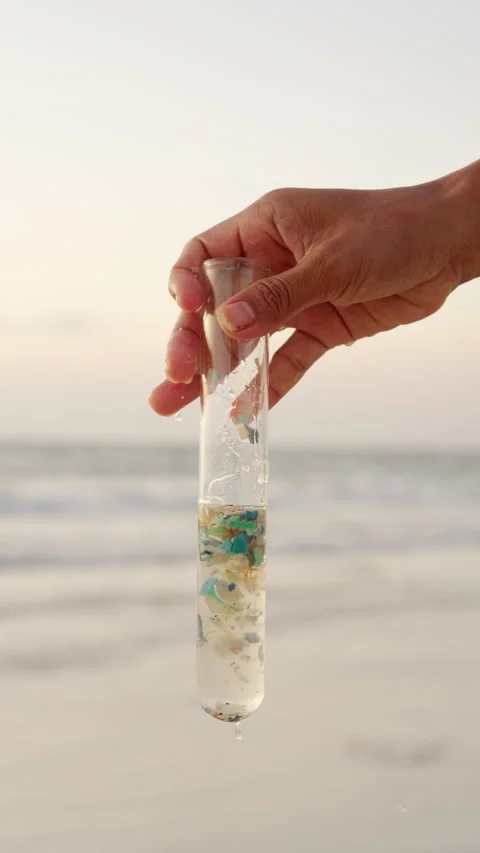 Hand holds sample of microplastic pollution, ocean plastic, polluted water Stock Footage 306720695