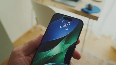 Hand holds smartphone with face recognition technology unlocking the device Stock Footage 343259401