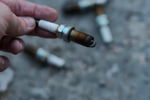 The hand holds the spark plug. Foto stock