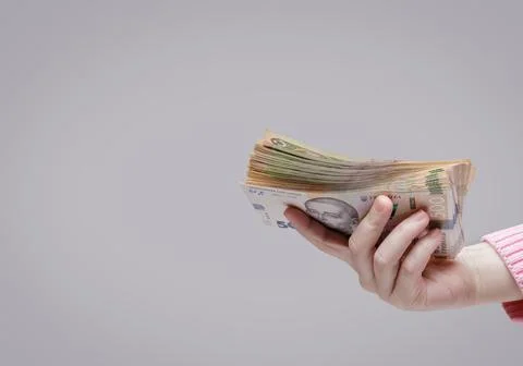 Hand holds a stack of five hundred hryvnia bills, side view Stock Photos