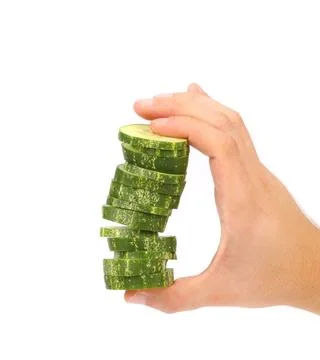  Hand holds stack of sliced cucumber. Hand holds stack of sliced cucumber.... 스톡 사진