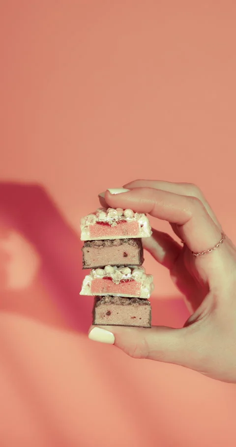 Hand Holds Stack of Strawberry Chocolate Bars Stock Footage 309942590