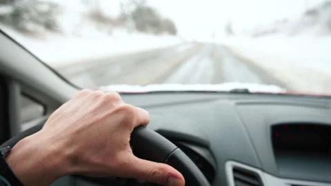 Hand holds steering wheel, control makes hello gesture Winter slippery road Vídeo Stock 148882744