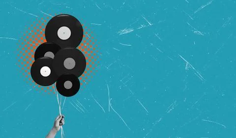 A hand holds strings attached to flying vintage vinyl records. The colorful a Stockfoto's