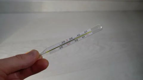 A hand holds a thermometer with high temperature 库存影片 142846527
