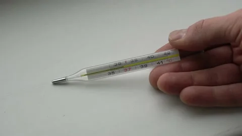 Hand holds a thermometer with normal temperature 库存影片 142907429